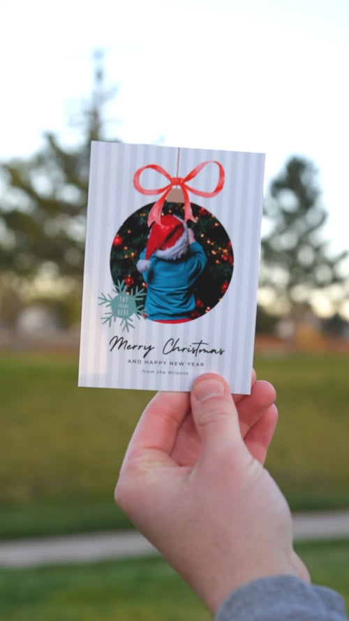 Video of a holiday card magnet; phone taps it to open a personalized family Christmas party video